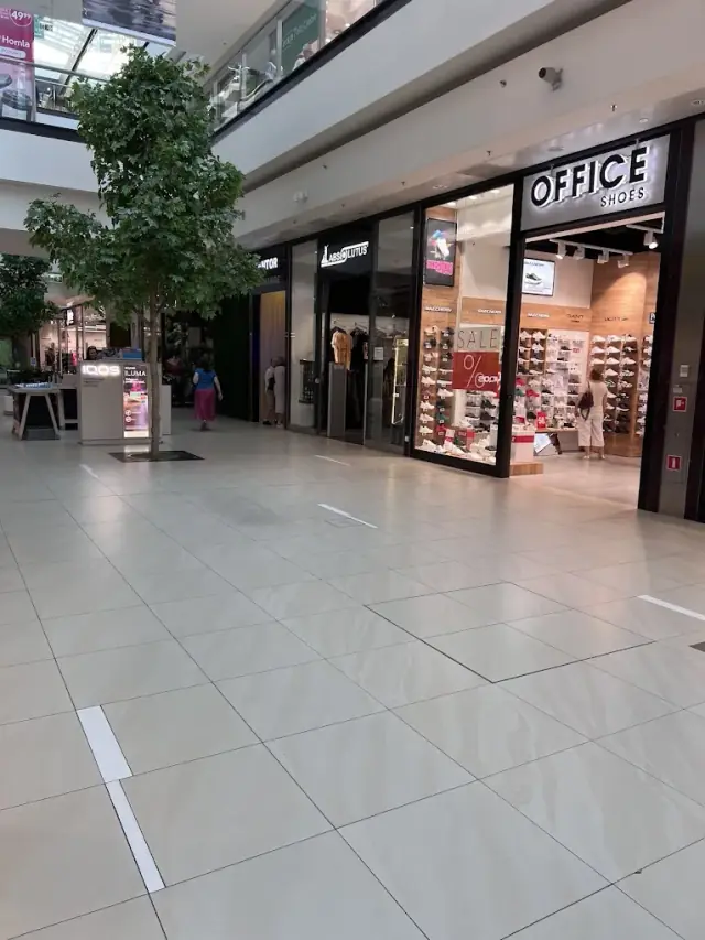 Szersze ujęcie alejki na poziomie -1 Galerii Echo prowadzącej do Kantor Sheikh, obok sklepów Absolutus i Office Shoes.